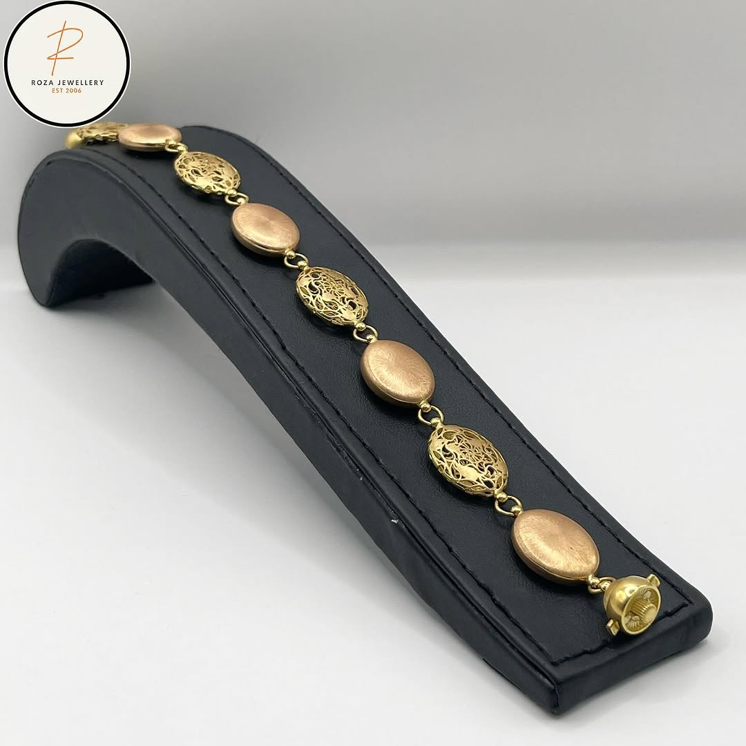 Two-tone oval-link bracelet displayed on a black stand