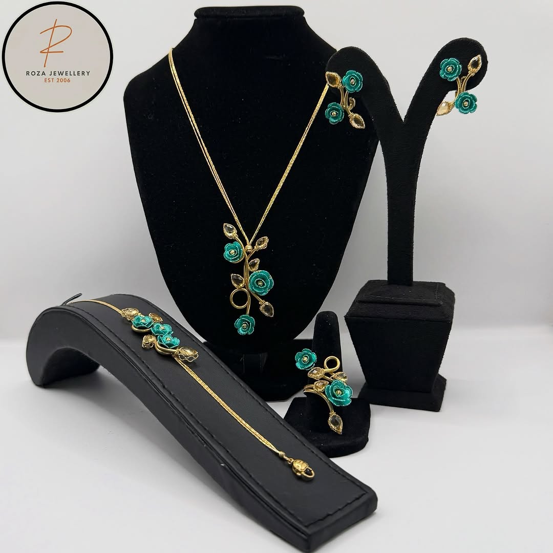 Turquoise floral necklace, earrings and bracelet displayed on black stands