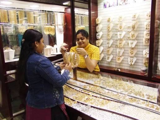 A customer viewing gold jewellery with assistance inside Roza